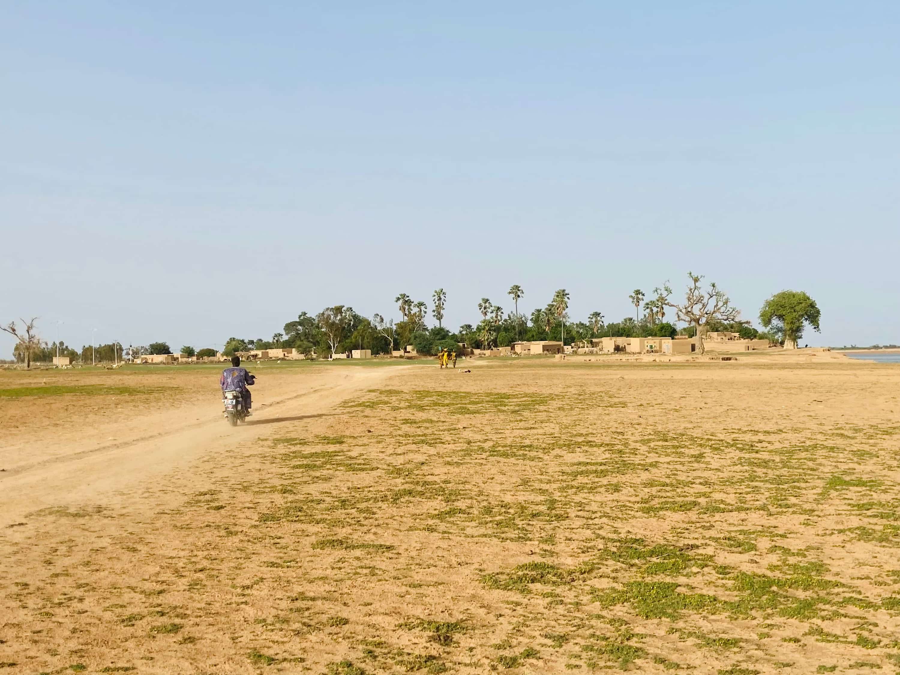 a man riding a motorcycle down a dirt road