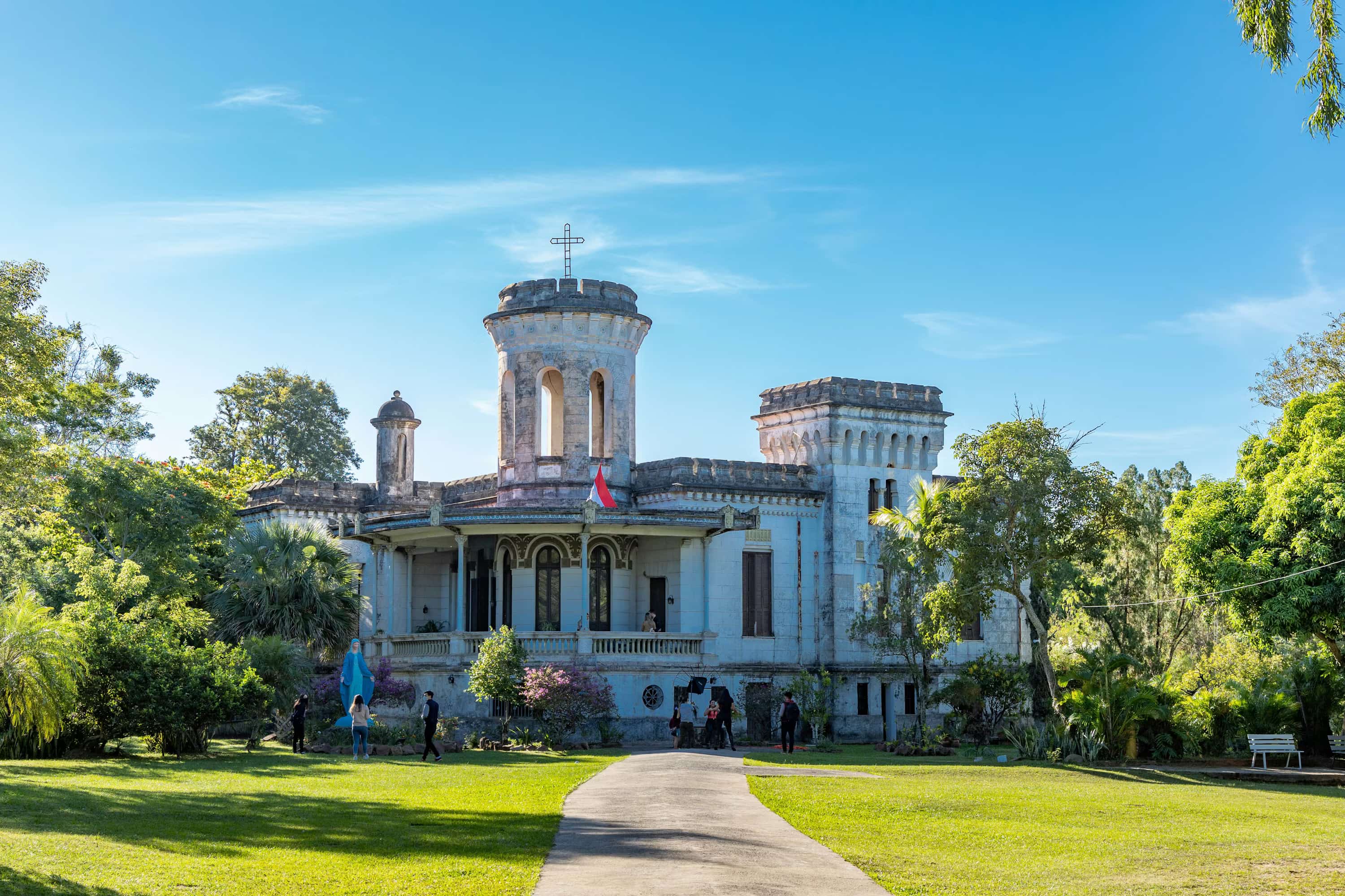white concrete building near green grass field under blue sky during daytime